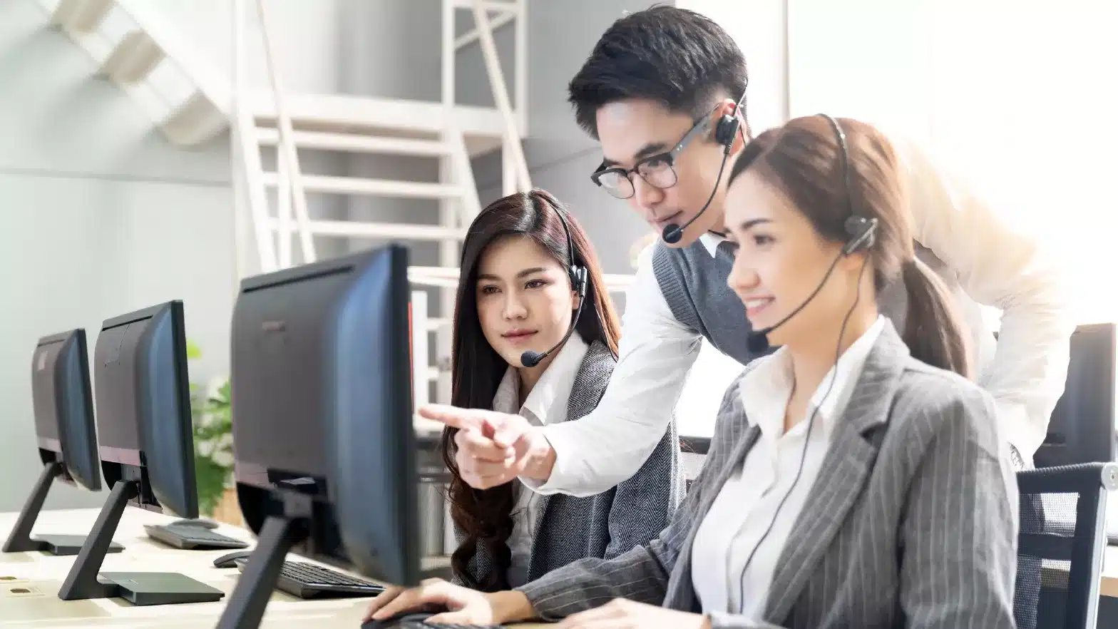 An image of man guiding his workers on help desk operations