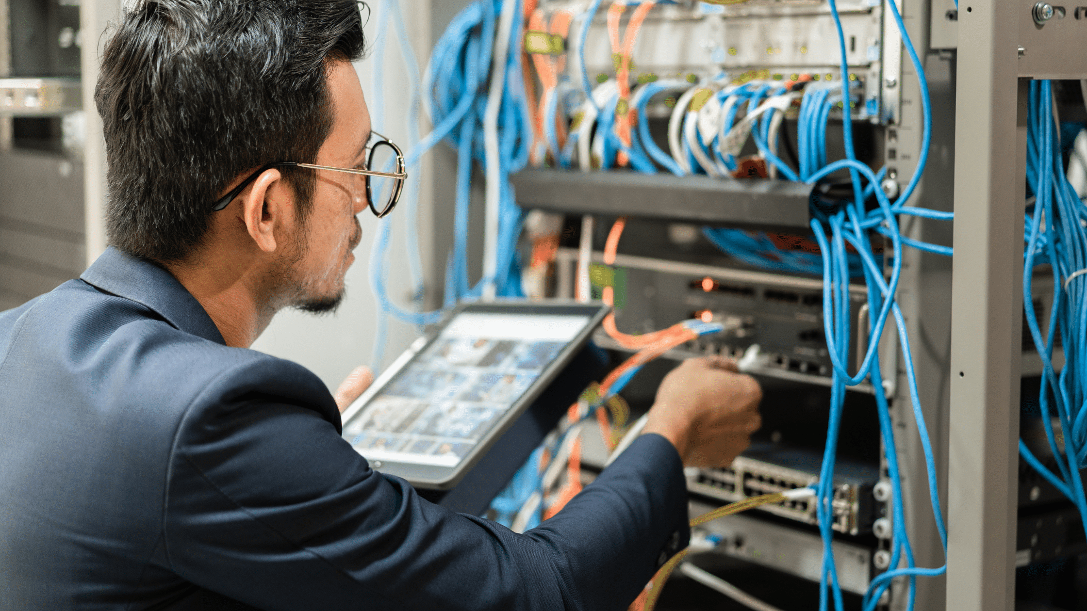 an image of a man as a systems engineer looking at server in IT infrastructure