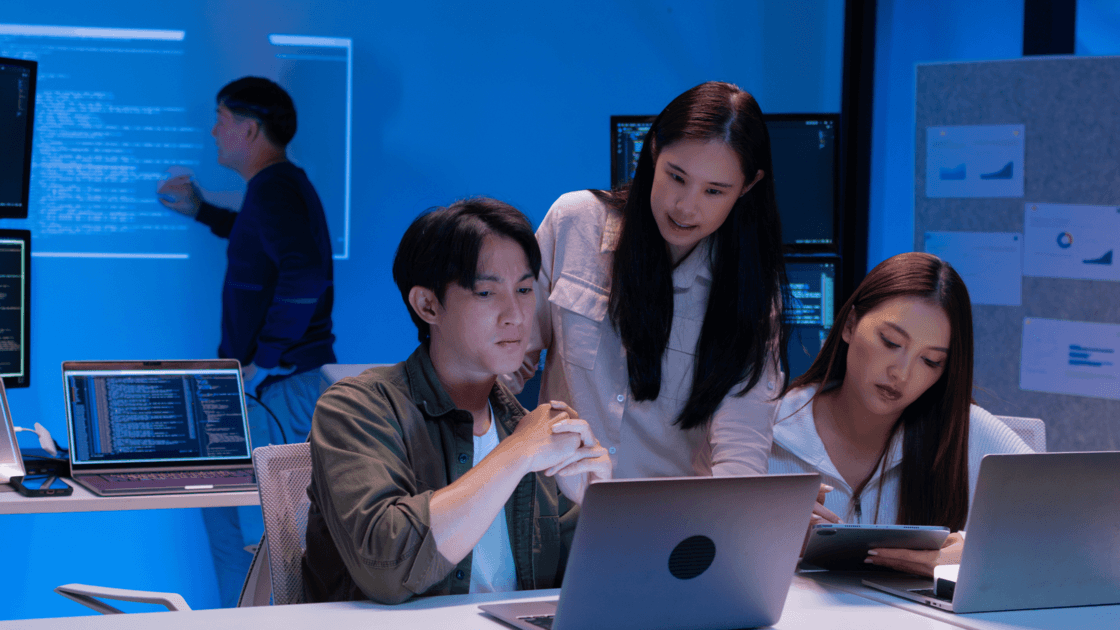 IT team collaborating on laptops in a cybersecurity, cloud and digital infrastructure workplace