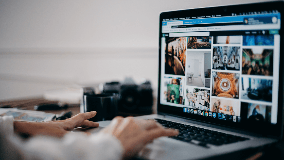 Laptop screen showing digital marketing content with a camera on the desk